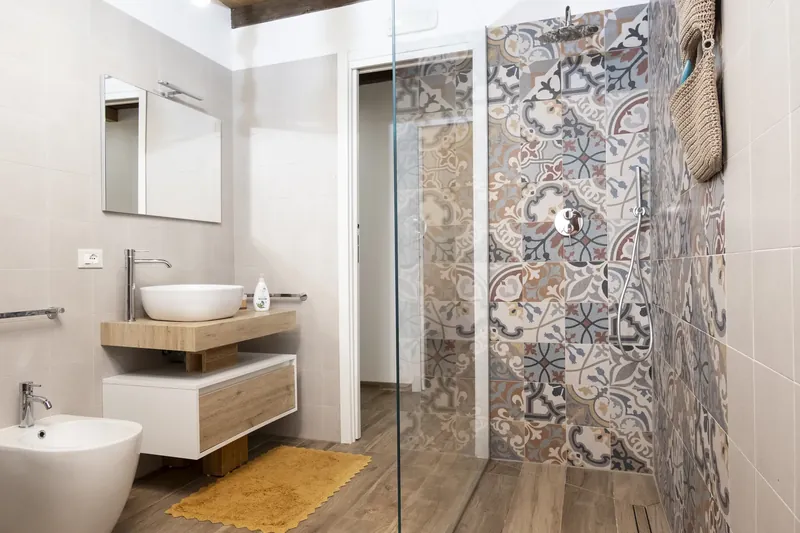 A bathroom with a marble vanity and a vessel basin