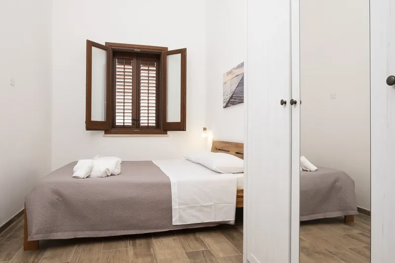 Bedroom with a mirrored wardrobe and window