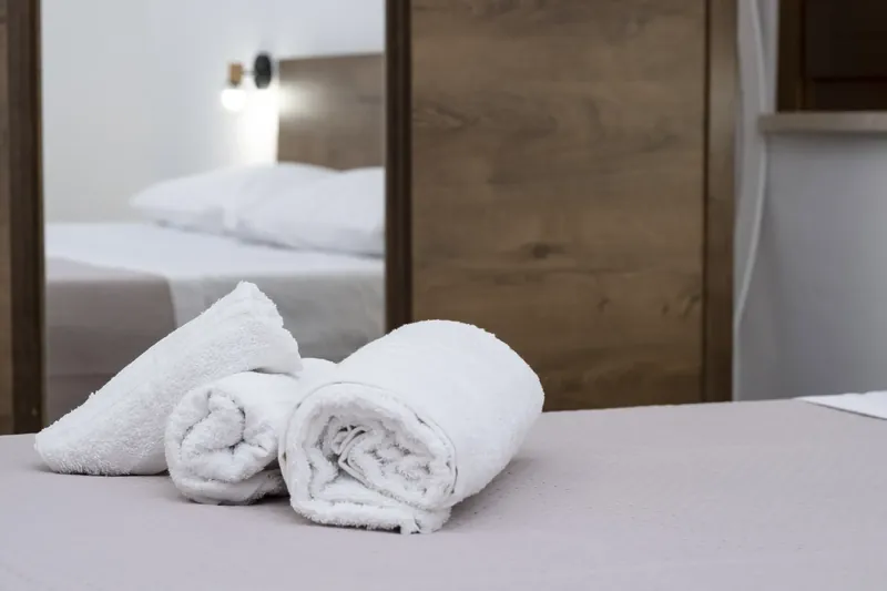 Turndown detail with fresh towels on the bed
