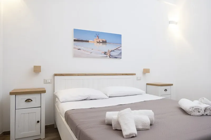 A double bedroom with a coastal painting above the bed