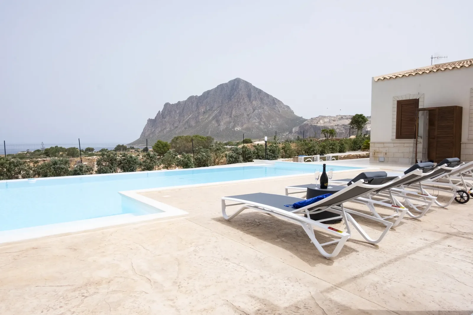 Villa Beatrice's private pool with sun loungers, Monte Cofano and the sea beyond