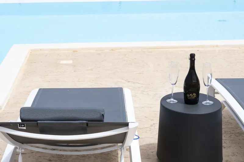 Sparkling wine on the pool edge facing Monte Cofano