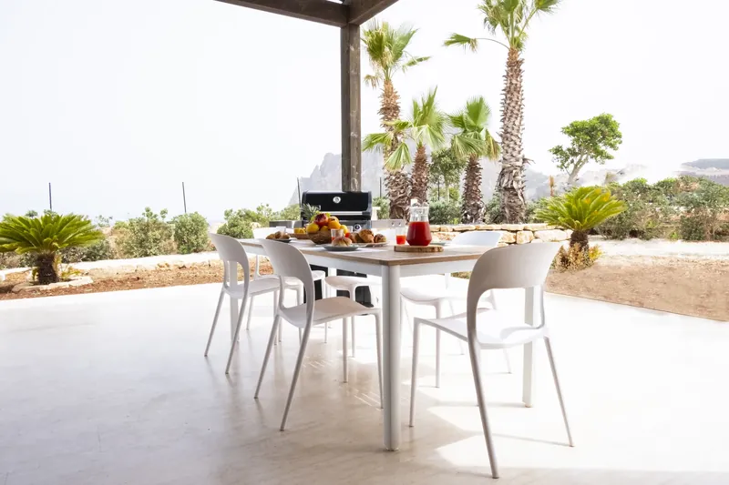 Covered terrace with a sofa, dining table and sea view